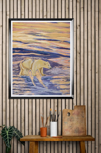 Framed artwork of a bear in water on a wooden wall with art supplies below.